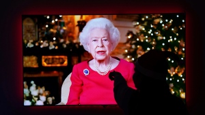A child is silhouetted on the television screen of her home in Larbert, England, Saturday, Dec. 25, 2021 as she watches Queen Elizabeth II giving her annual Christmas broadcast from Windsor Castle. (Andrew Milligan/PA via AP)