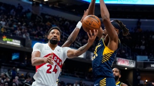 Toronto Raptors center Khem Birch (24) shoots under Indiana Pacers center Myles Turner (33) during the first half of an NBA basketball game in Indianapolis, Saturday, Oct. 30, 2021. (AP Photo/Michael Conroy) 
