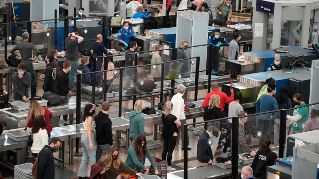 Travellers slog through the south security checkpoint in a terminal at Denver International Airport, Friday, Dec. 24, 2021, in Denver. More than 200 flights were cancelled by carriers out of Denver International because COVID-19 issues have created a shortage of workers. (AP Photo/David Zalubowski)