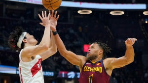 Toronto Raptors' Yuta Watanabe, left, and Cleveland Cavaliers' Justin Anderson battle for a loose ball in the first half of an NBA basketball game, Sunday, Dec. 26, 2021, in Cleveland. (AP Photo/Tony Dejak) 