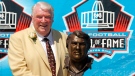 Broadcaster and former Oakland Raiders coach John Madden poses with his bust after enshrinement into the Pro Football Hall of Fame Saturday, Aug. 5, 2006, in Canton, Ohio. John Madden, the Hall of Fame coach turned broadcaster whose exuberant calls combined with simple explanations provided a weekly soundtrack to NFL games for three decades, died Tuesday, Dec. 28, 2021, the NFL said. He was 85.(AP Photo/Mark Duncan, File)
