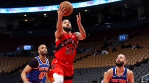 Toronto Raptors' Fred VanVleet, centre, scores a basket as New York Knicks' Evan Fournier, right, and Taj Gibson look on during first half NBA basketball action in Toronto on Sunday, January 2, 2022. THE CANADIAN PRESS/Chris Young 