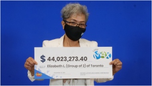 Elizabeth Lumbo holds a $44-million cheque after winning the Lotto Max jackpot with her ex-husband. (Supplied)