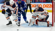 Edmonton Oilers' Slater Koekkoek (20) and Toronto Maple Leafs' Wayne Simmonds (24) battle for the puck in front of Oilers goaltender Mike Smith (41) during second period NHL hockey action in Toronto on Wednesday, January 5, 2022. THE CANADIAN PRESS/Frank Gunn 
