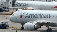 In this file photo, American Airlines passenger jets prepare for departure, Wednesday, July 21, 2021, near a terminal at Boston Logan International Airport, in Boston. (AP Photo/Steven Senne) 