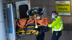 Paramedics transfer a patient out of their ambulance to the emergency department at Michael Garron Hospital during the COVID-19 pandemic in Toronto on Monday, January 10, 2022. Ambulances have been in short supply in some regions through out the province of Ontario. THE CANADIAN PRESS/Nathan Denette