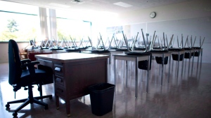 A empty teacher's desk is pictured in an empty classroom is seen on Sept. 5, 2014. THE CANADIAN PRESS/Jonathan Hayward 