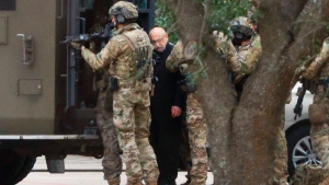 Shortly after 5 p.m., local time, authorities escort a hostage out of the Congregation Beth Israel synagogue in Colleyville, Texas, Saturday, Jan. 15, 2022. Police said the man was not hurt and would be reunited with his family. (Elias Valverde/The Dallas Morning News via AP)