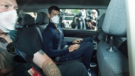 Serbian tennis player Novak Djokovic, center, rides in car as he leaves a government detention facility before attending a court hearing at his lawyers office in Melbourne, Australia, Sunday, Jan. 16, 2022.  (James Ross/AAP via AP) 