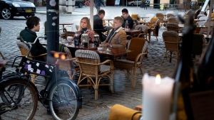 People sit outside the reopened Huks Fluks restaurant at Graabroedre Square in Copenhagen, Monday, May 18, 2020. Restaurants, cafes and several other places opened today with restrictions such as rules concerning opening hours and physical distance due to the coronavirus outbreak. (Liselotte Sabroe/Ritzau Scanpix via AP) 