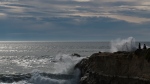 People watch large waves crash on Lighthouse Point in Santa Cruz, Calif., Saturday, Jan. 15, 2022. (AP Photo/Nic Coury) 