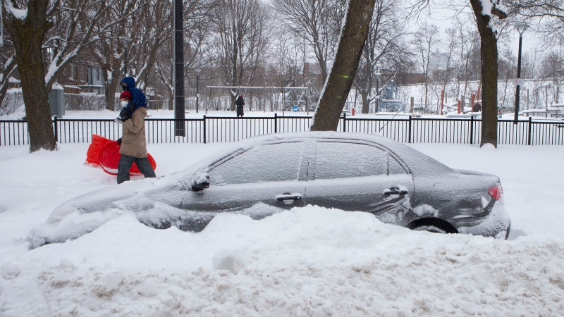 A car remains behind a snowbank in downtown Toronto as a heavy snowfall affects the greater Toronto area on Monday January 17, 2022. THE CANADIAN PRESS/Chris Young