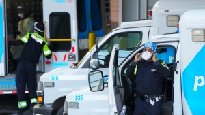 A paramedic adjusts his protective mask as he transfers a patient out of an ambulance to the emergency department at Michael Garron Hospital during the COVID-19 pandemic in Toronto on Monday, January 10, 2022. Ambulances have been in short supply in some regions through out the province of Ontario. THE CANADIAN PRESS/Nathan Denette 