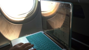 A passenger uses a laptop aboard a commercial airline flight from Boston to Atlanta on July 1, 2017. (AP Photo/Bill Sikes, File)