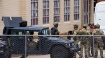 Law enforcement teams stage near Congregation Beth Israel while conducting SWAT operations in the 6100 block of Pleasant Run Road on Saturday, Jan. 15, 2022, in Colleyville, Texas. Authorities said a man took hostages Saturday during services at the Texas synagogue. (Smiley N. Pool/The Dallas Morning News via AP)