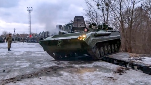In this photo taken from video provided by the Russian Defense Ministry Press Service, A Russian armored vehicle drives off a railway platform after arrival in Belarus, Wednesday, Jan. 19, 2022. (Russian Defense Ministry Press Service via AP)