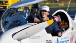 Belgium-British teenage pilot Zara Rutherford smiles as she gets out of the cockpit after landing her Shark ultralight plane at the Kortrijk airport in Kortrijk, Belgium, Thursday, Jan. 20, 2022. The 19-year-old Belgium-British pilot Zara Rutherford has set a world record as the youngest woman to fly solo around the world, touching her small airplane down in western Belgium on Thursday, 155 days after she departed. Rutherford will find herself in the Guinness World Records book after setting the mark that had been held by 30-year-old American aviator Shaesta Waiz since 2017. (AP Photo/Geert Vanden Wijngaert)