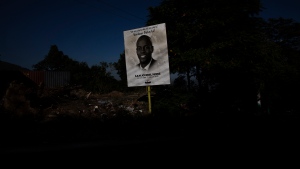 FILE - A poster depicting Haiti's President Jovenel Moise, who was assassinated in July, towers over a road in Port-au-Prince, Haiti, Tuesday, Sept. 28, 2021. (AP Photo/Rodrigo Abd) 