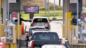 FILE - Cars line up to enter the U.S. from Canada at the Peace Arch border crossing Monday, Nov. 8, 2021, in Blaine, Wash. (AP Photo/Elaine Thompson) 