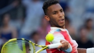 Felix Auger-Aliassime of Canada plays a forehand return to Daniel Evans of Britain during their third round match at the Australian Open tennis championships in Melbourne, Australia, Saturday, Jan. 22, 2022. (AP Photo/Simon Baker)