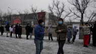Residents wearing masks to protect from the coronavirus waits in line at a nuclei test station in Beijing, China, Friday, Jan. 21, 2022. The sweeping "zero-tolerance" policies that China has employed to protect its people and economy from COVID-19 may, paradoxically, make it harder for the country to exit the pandemic. (AP Photo/Ng Han Guan)