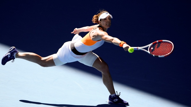 Alize Cornet of France makes a backhand return to Simona Halep of Romania during their fourth round match at the Australian Open tennis championships in Melbourne, Australia, Monday, Jan. 24, 2022. (AP Photo/Andy Brownbill) 