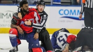 After an on-ice fight, South Carolina Stingrays defenseman Jordan Subban (5), left, is held by linesman Shane Gustafson while Jacksonville Icemen defenseman Jacob Panetta (15) is face-down on the ice engaged with another player during overtime of an ECHL hockey game in Jacksonville, Fla., Saturday, Jan. 22, 2022. (AP Photo/Gary McCullough) 