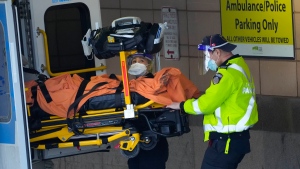 Paramedics transfer a patient out of their ambulance to the emergency department at Michael Garron Hospital during the COVID-19 pandemic in Toronto on Monday, January 10, 2022.  THE CANADIAN PRESS/Nathan Denette 