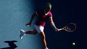 Rafael Nadal of Spain plays a forehand return to Denis Shapovalov of Canada during their quarterfinal match at the Australian Open tennis championships in Melbourne, Australia, Tuesday, Jan. 25, 2022. (AP Photo/Tertius Pickard)