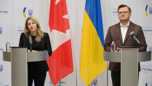 In this photo provided by Ukrainian Foreign Ministry Press Office, Canada's Minister of Foreign Affairs Melanie Joly and Ukrainian Foreign Minister Dmytro Kuleba attend their news conference in Kyiv, Ukraine, Tuesday, Jan. 18, 2022. (Ukrainian Foreign Ministry Press Office via AP) 