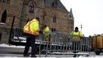 Public Works staff prepare fencing in front of Parliament Hill’s West Block in Ottawa, on Thursday, Jan. 27, 2022, before a cross-country convoy protesting a federal vaccine mandate for truckers is expected on Saturday. THE CANADIAN PRESS/Justin Tang