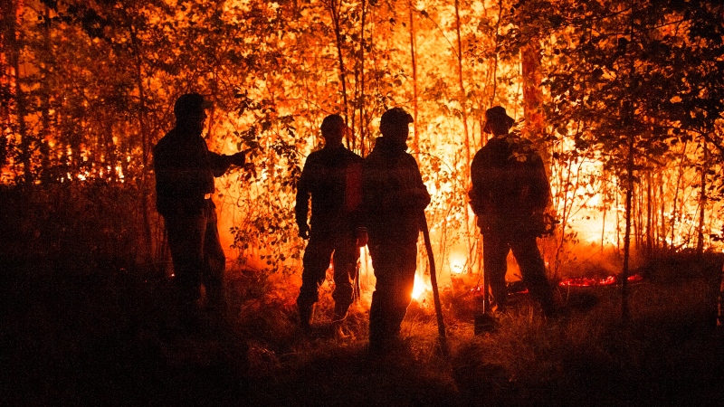 Firefighters work at the scene of forest fire near Kyuyorelyakh village at Gorny Ulus area, west of Yakutsk, in Russia Thursday, Aug. 5, 2021. A warming planet and land use changes mean more wildfires will scorch large parts of the globe in coming decades. That's according to a UN report released Wednesday, Feb. 23, 2022 that says many governments are ill-prepared to address the problem. (AP Photo/Ivan Nikiforov, File)