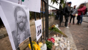 An image of Foo Fighters' drummer Taylor Hawkins adorns a makeshift memorial outside the hotel where Hawkins was found dead, in northern Bogota, Colombia, Saturday, March 26, 2022. (AP Photo/Fernando Vergara) 