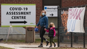 People walk past a COVID-19 assessment centre outside a hospital in Toronto on Monday, April 4, 2022. THE CANADIAN PRESS/Nathan Denette