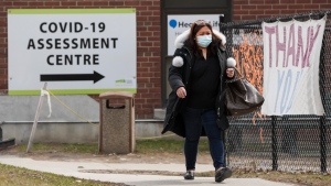 A woman walks past a COVID-19 assessment centre outside a hospital in Toronto on Monday, April 4, 2022. THE CANADIAN PRESS/Nathan Denette 