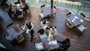 A server brings food to a table as people dine at a restaurant in Vancouver, on Tuesday, September 21, 2021. British Columbia's COVID-19 vaccine card system went into effect last week. Anyone who wants access to a range of non-essential indoor services, including restaurants, must show proof of at least one dose of vaccine, with a second shot required by Oct. 24. THE CANADIAN PRESS/Darryl Dyck