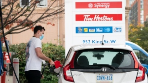 FILE - A man fills his vehicle with gas during the COVID-19 pandemic in Toronto on Friday, October 8, 2021. Gas prices across Canada and the world are hitting record highs. THE CANADIAN PRESS/Nathan Denette 