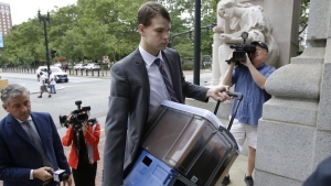 Nathan Carman, center, carries documents as he arrives at federal court, Tuesday, Aug. 13, 2019, in Providence, R.I.  (AP Photo/Steven Senne, File)