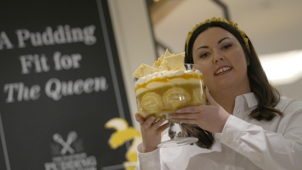 Jemma Melvin the Platinum Jubilee Pudding winner poses for the media with her creation, at a department store in London, Friday, May 13, 2022. Jemma was chosen from over 5000, entries. The 31-year-old copywriter's seven-layer lemon Swiss roll and amaretti trifle beat 5,000 desserts in a U.K.-wide competition to become the official pudding — or dessert, if you’re not British — of the Queen’s Platinum Jubilee. (AP Photo/Alastair Grant)
