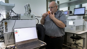 Israeli Harel Hershtik, vice president of strategy and technology at Scentech Medical, demonstrates his company's product, which he says  can detect certain diseases by analysing a patient's breath, at the company's office in Rehovet, Israel, May 3, 2022. When he was 20 years old, Hershtik planned and executed a murder, shooting his victim in the head and burying the body in a crime that a quarter of a century later is still widely remembered for its grisly details. Today, he is the brains behind an Israeli health-tech startup with the backing of prominent public figures and deep-pocketed investors. (AP Photo/Tsafrir Abayov)