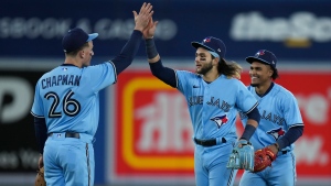 Toronto Blue Jays third baseman Matt Chapman (26) celebrates with teammates Bo Bichette, centre, and Santiago Espinal after defeating the Seattle Mariners during ninth inning American League, MLB baseball action in Toronto on Monday, May 16, 2022. THE CANADIAN PRESS/Nathan Denette