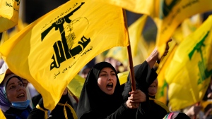 A Hezbollah supporter shouts slogans and waves her group flag, during an election campaign, in the southern suburb of Beirut, Lebanon, Tuesday, May 10, 2022. The parliamentary elections will take place this Sunday, on May 15, which held once every four years and last vote in 2018 gave majority seats to the powerful Iran-backed Hezbollah group and its allies. (AP Photo/Hussein Malla)