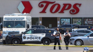 Police walk outside the Tops grocery store on Sunday, May 15, 2022, in Buffalo, N.Y. A white 18-year-old wearing military gear and livestreaming with a helmet camera opened fire with a rifle at the supermarket, killing and wounding people in what authorities described as â€œracially motivated violent extremism.â€ (AP Photo/Joshua Bessex)