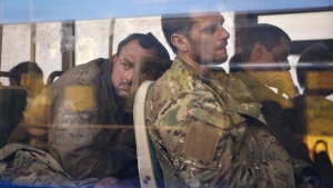 Ukrainian servicemen sit in a bus after they were evacuated from the besieged Mariupol's Azovstal steel plant, near a remand prison in Olyonivka, in territory under the government of the Donetsk People's Republic, eastern Ukraine, Tuesday, May 17, 2022. (AP Photo/Alexei Alexandrov)