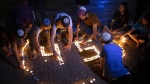 FILE - Israeli youths light candles in memory of the 45 ultra-Orthodox Jews killed in a stampede at a religious festival on Friday, during a vigil in Tel Aviv, Israel, Sunday, May 2, 2021. Police made preparations at a Jewish holy site at Mt. Meron in northern Israel ahead of the arrival of thousands of mostly ultra-Orthodox worshipers and revelers on Wednesday, May 18, 2022, a year after a chaotic stampede linked to overcrowding left 45 people dead. (AP Photo/Oded Balilty, File)