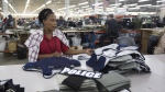 FILE - Laurette Eugene assembles a body armor vest at the Point Blank Body Armor factory in Pompano Beach, Fla., Sept. 19, 2014. When a shooter attacked a supermarket in Buffalo, New York,May 14, 2022, its security guard tried to stop him. At least one of the guard's shots hit the gunman, but it didn’t stop the deadly rampage because the gunman was wearing body armor. (AP Photo/J Pat Carter, File)