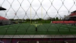 The field at TD Place, home of the Ottawa Redblacks, is seen from beyond an exterior wire fence in Ottawa on Tuesday, May 17, 2022. Redblacks players joined players from other teams in the CFL that are not attending their training camps after a new collective bargaining agreement was not reached between the league and the player's association. THE CANADIAN PRESS/Justin Tang