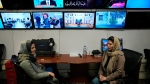Afghan journalists Banafsha Binesh, right, speaks with her colleague Wheeda Hassan, at TOLO TV newsroom in Kabul, Afghanistan, Tuesday, Feb. 8, 2022. (AP Photo/Hussein Malla)