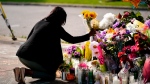 Shannon Waedell-Collins pays her respects at the scene of Saturday's shooting at a supermarket, in Buffalo, N.Y., Wednesday, May 18, 2022. (AP Photo/Matt Rourke) 