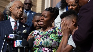 Tirzah Patterson, former wife of Buffalo shooting victim Heyward Patterson, speaks as her son, Jacob Patterson, 12, covers his face during a press conference outside the Antioch Baptist Church on Thursday, May 19, 2022, in Buffalo, N.Y. (AP Photo/Joshua Bessex)